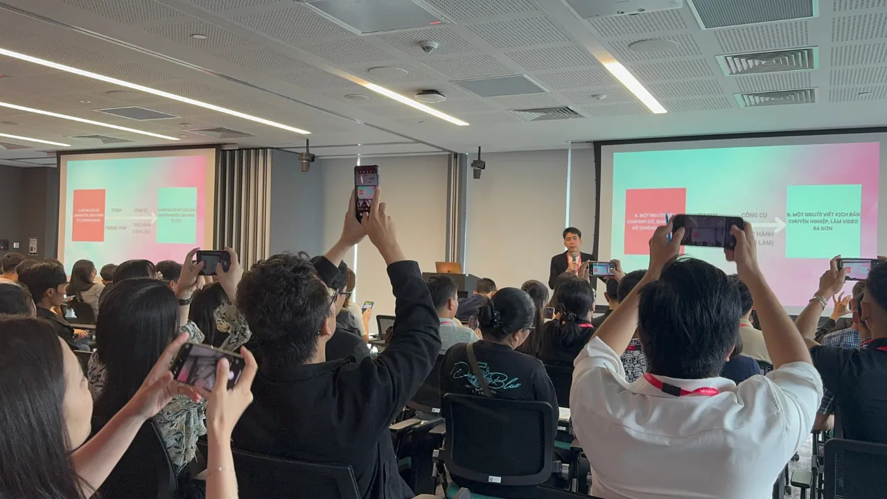 Students holding up phones to record a slide on the scriptwriting process for videos that drive orders